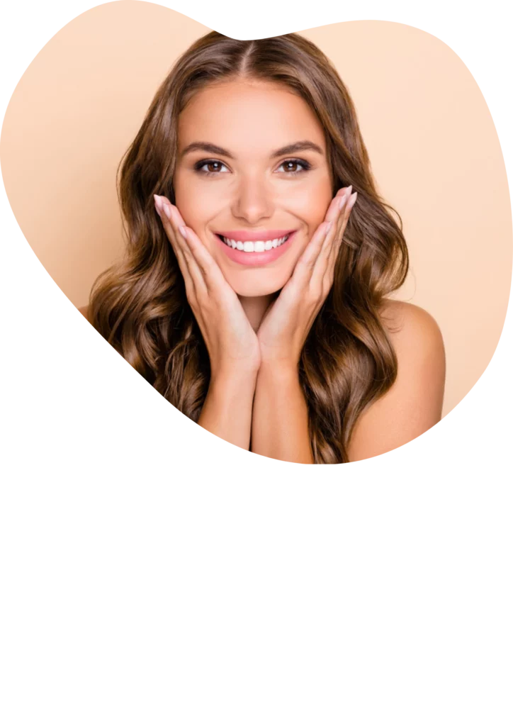 A beautiful woman smiling while holding her face after dental treatment at beyondental