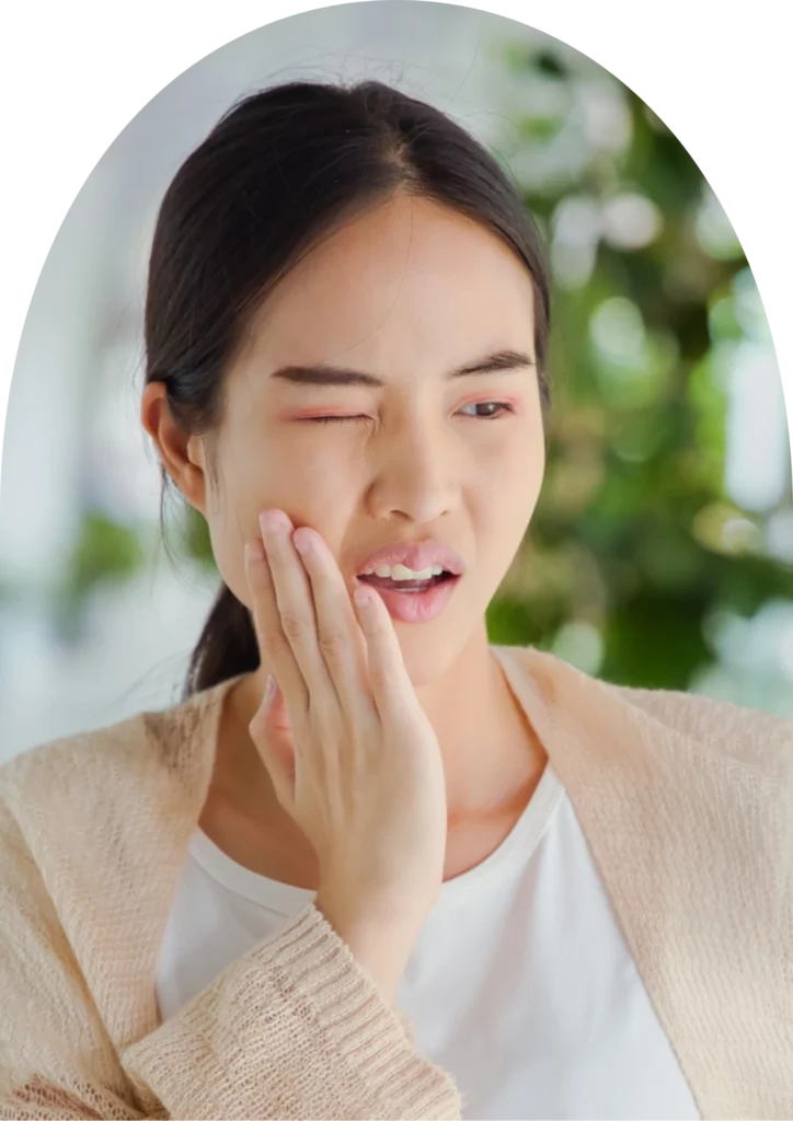 A woman visited beyondental for a wisdom tooth extraction, holding her face